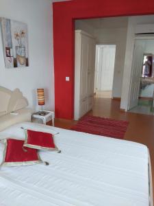 グランベにあるLa Kanazikの赤い壁の客室で、白い大型ベッド1台が備わります。