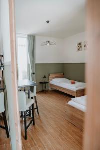 Zimmer mit 2 Betten, einem Tisch und einem Schreibtisch in der Unterkunft Ako doma in Poltár