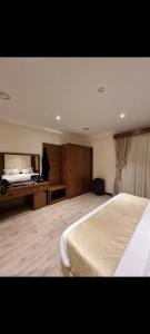 una grande camera da letto con un grande letto e una scrivania di فيوبارك للشقق الفندقية a Al Hofuf