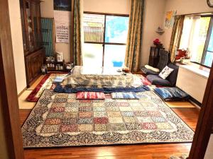 a bedroom with a bed and a rug on the floor at 花源 in Beppu