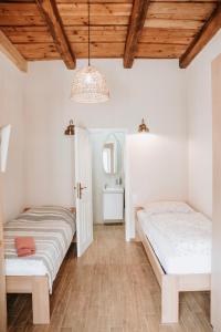 2 Betten in einem Zimmer mit Holzdecken und einem Spiegel in der Unterkunft Ako doma in Poltár