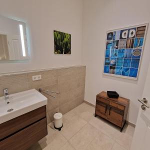 een badkamer met een wastafel en een spiegel bij Apartment mit Parkblick & Massagestuhl in Leipzig