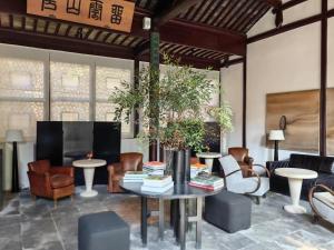 uma sala de estar com mesa e cadeiras em Jiangnan House Changyuan em Suzhou
