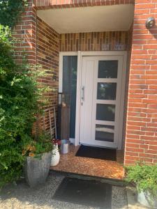 a white door on a brick building with plants at Lindenblüte in Eggstedt +13 photos