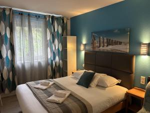 a bedroom with a bed with two towels on it at Hotel La Voilerie Cancale bord de mer in Cancale