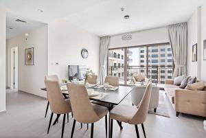comedor y sala de estar con mesa y sillas en StoneTree - Spacious 2BR Apartment in Golf Views Block A, en Dubái