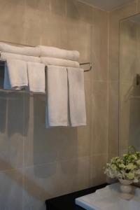 un grupo de toallas colgando de un estante en el baño en SunSeaSand Hotel Patong - SHA Certified, en Patong Beach