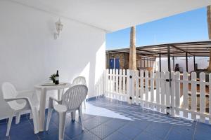 a white dining room with a table and chairs at Casa Gloria in Puerto del Carmen