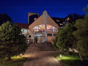 a building with a staircase in front of it at night at Politechnika Warszawska Ośrodek Wypoczynkowy in Sarbinowo