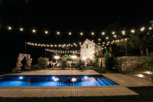 a backyard at night with a swimming pool and lights at Škerlj Wine Estate in Tomaj