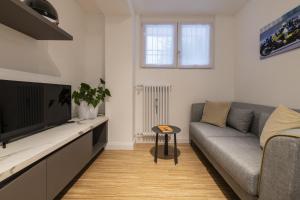 uma sala de estar com um sofá e uma televisão de ecrã plano em Easylife - Tranquillo studio vicino Prada em Milão