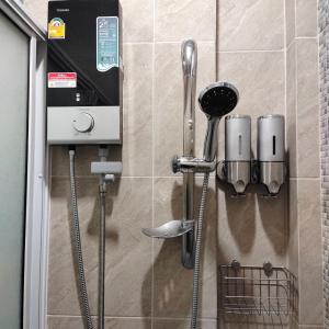 um chuveiro com utensílios pendurados numa parede em Baan Pak Arom Resort Chanthaburi 
