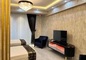 a hotel room with two beds and a tv and a chair at sutluce's luxury suite with a golden horn view in Istanbul