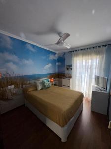 a bedroom with a bed with a painting of the beach at Mikalita in San Fernando