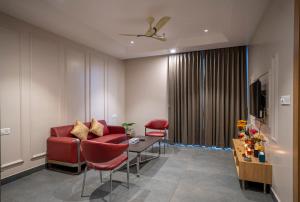 a living room with a red couch and chairs at Vacanza By Westay Luxury Home in Gurgaon