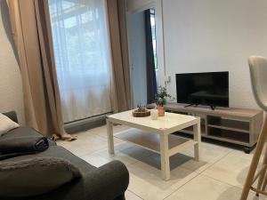 sala de estar con TV y mesa de centro blanca en Le Joli T2 - Agréable - Parking, en Annemasse