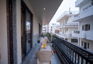 a balcony with tables and chairs on a building at Vacanza By Westay Luxury Home in Gurgaon