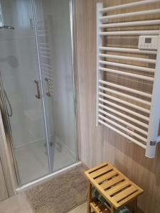 a bathroom with a shower and a wooden stool at Tiny house proche de Morgat in Crozon
