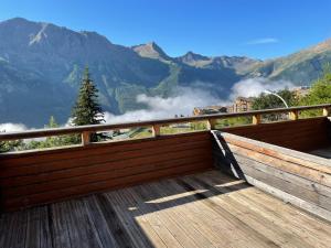 a wooden balcony with a view of mountains at Orcière-Merlette Studio 2-4 pers au calme exposé plein sud et à 5mn à pied des remontées mécaniques in Orcières