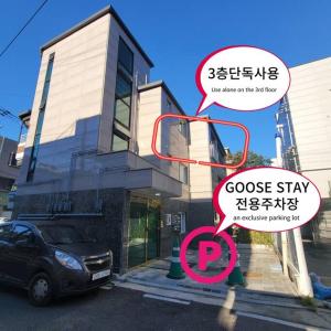 un coche está estacionado frente a un edificio en Goose Stay, en Bucheon