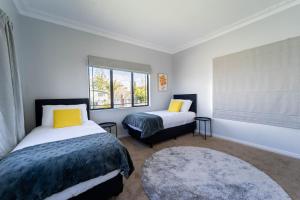 a bedroom with two beds and a window at Family Friendly Oceanview Howick Home - Pets+ in Auckland