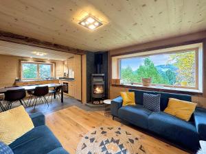 a living room with a couch and a large window at Chalet a Didi - Alps Paradise - 4 Vallees in La Tzoumaz