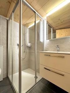 La salle de bains est pourvue d'une douche et d'un lavabo. dans l'établissement Chalet a Didi - Alps Paradise - 4 Vallees, à La Tzoumaz