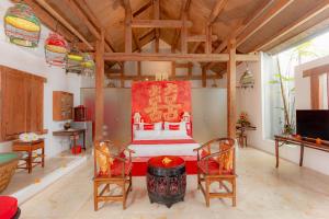a bedroom with a bed and two chairs in a room at Bali Ginger Suites & Villa in Seminyak