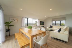 a living room with a table and a couch at Family Friendly Oceanview Howick Home - Pets+ in Auckland
