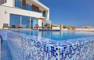 a swimming pool in front of a house at Sea Pearl Luxury Beachfront Villas in Ayia Napa