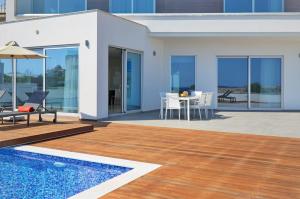 a villa with a swimming pool and a patio at Sea Pearl Luxury Beachfront Villas in Ayia Napa