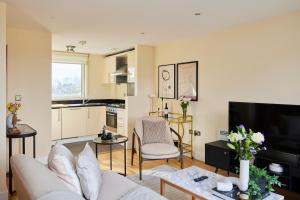 a living room with a couch and a tv at The Weavers Field Place - Classy 3BDR Flat with Terrace in London