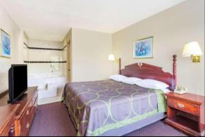 une chambre d'hôtel avec un lit et une télévision dans l'établissement Ashland Studio Inn By OYO Richmond North near Kings Dominion, à Ashland