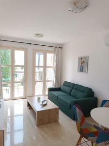 a living room with a green couch and a table at Aphrodite Hills Adonis Apartment in Kouklia