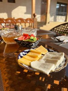 a plate of cheese and vegetables on a table at Hotel SUZUK-OTA in Tashkent
