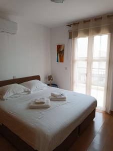 a bedroom with a large bed with two towels on it at Aphrodite Hills Adonis Apartment in Kouklia