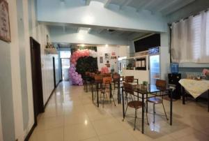 Habitación con comedor con mesas y sillas. en Royal Duchess Pension, en Puerto Princesa City