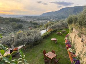 Blick auf einen Garten mit Tischen und Stühlen in der Unterkunft Domus Umbra in Terni