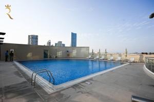 a large swimming pool on the roof of a building at Sunshine pool view 1BR apartment in Abu Dhabi