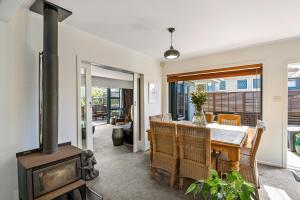 a dining room with a table and a wood stove at Ultimate beach location in Mount Maunganui
