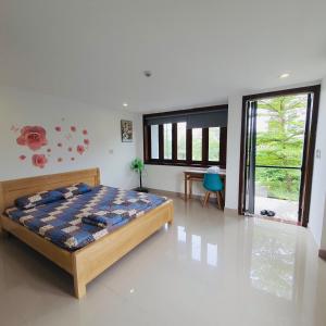 a bedroom with a bed and a large window at Kemnpi Homestay in Hue