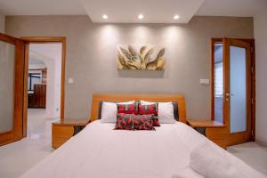 een slaapkamer met een groot wit bed en 2 stoelen bij Sunflower in Birkirkara