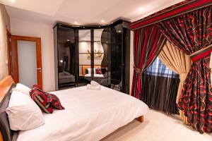 een slaapkamer met een bed en een raam met gordijnen bij Sunflower in Birkirkara