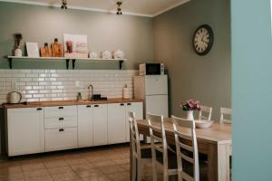 a kitchen with a table and a clock on the wall at Ako doma in Poltár