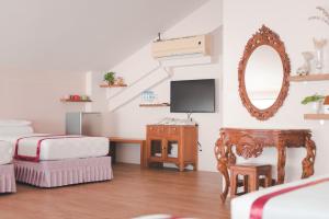 a bedroom with a bed and a desk with a mirror at XinFu Traveler Inn in Taiping