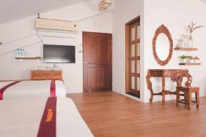 a bedroom with a bed and a tv and a mirror at XinFu Traveler Inn in Taiping