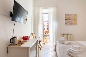 パレルモにあるPunto al Capo Appartamento intero o stanze matrimoniali con bagno privatoの白い部屋(ベッド1台、壁掛けテレビ付)