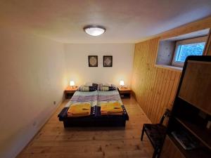 sypialnia z łóżkiem i dwoma lampami na dwóch stołach w obiekcie Chalupa pod bralom 
