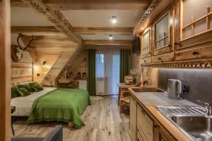 a bedroom in a log cabin with a bed and a sink at Apartamenty u Grażyny in Murzasichle