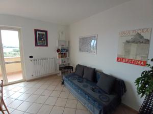 sala de estar con sofá y ventana en Degli Angioini Holiday Home, en Caulonia Marina